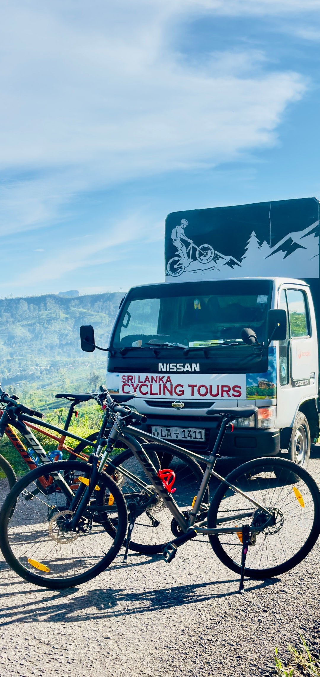 Cycling support vehicle and mountain bikes on a tea estate road in Sri Lanka