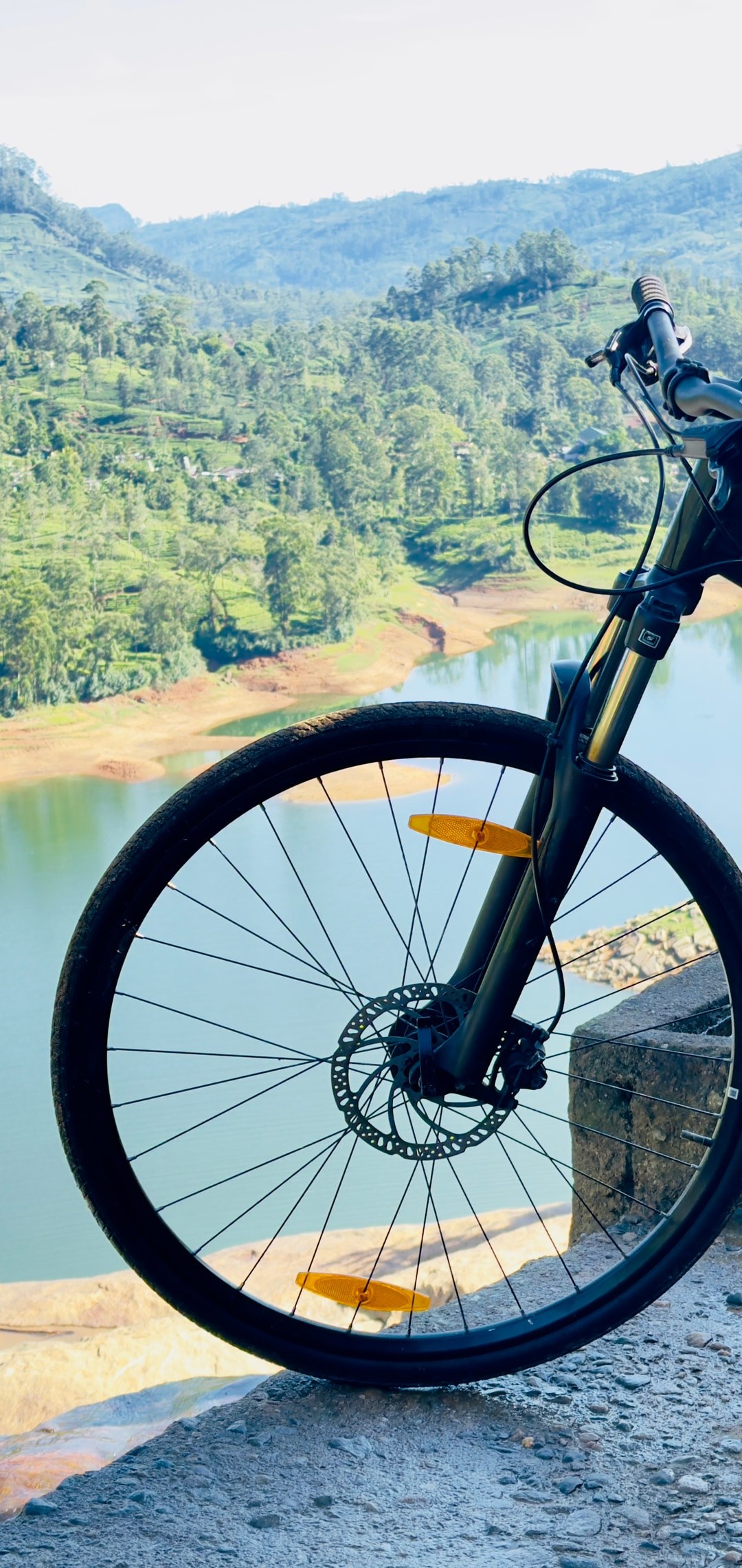 Mountain bike overlooking a lake and tea country valleys in Sri Lanka