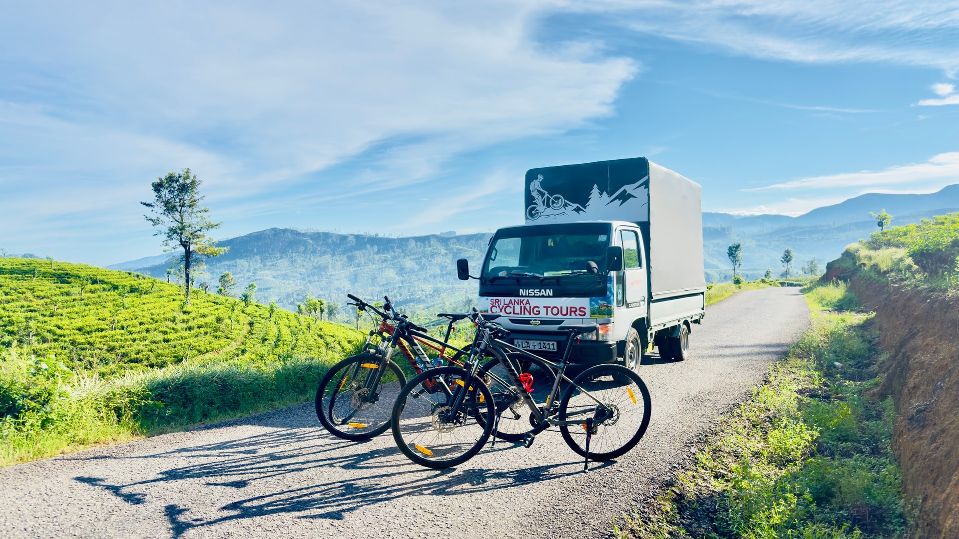 Cycling support vehicle and mountain bikes on a tea estate road in Sri Lanka