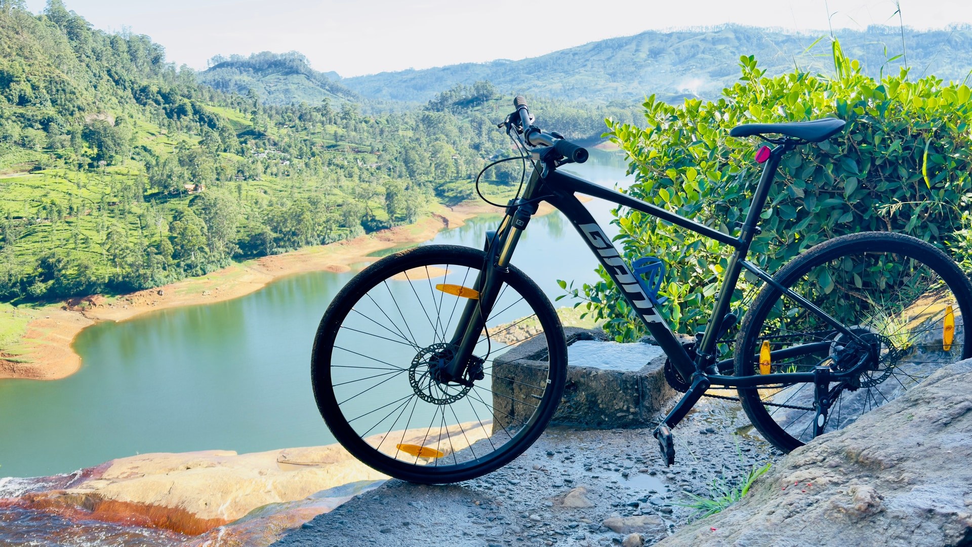 Mountain bike overlooking a lake and tea country valleys in Sri Lanka